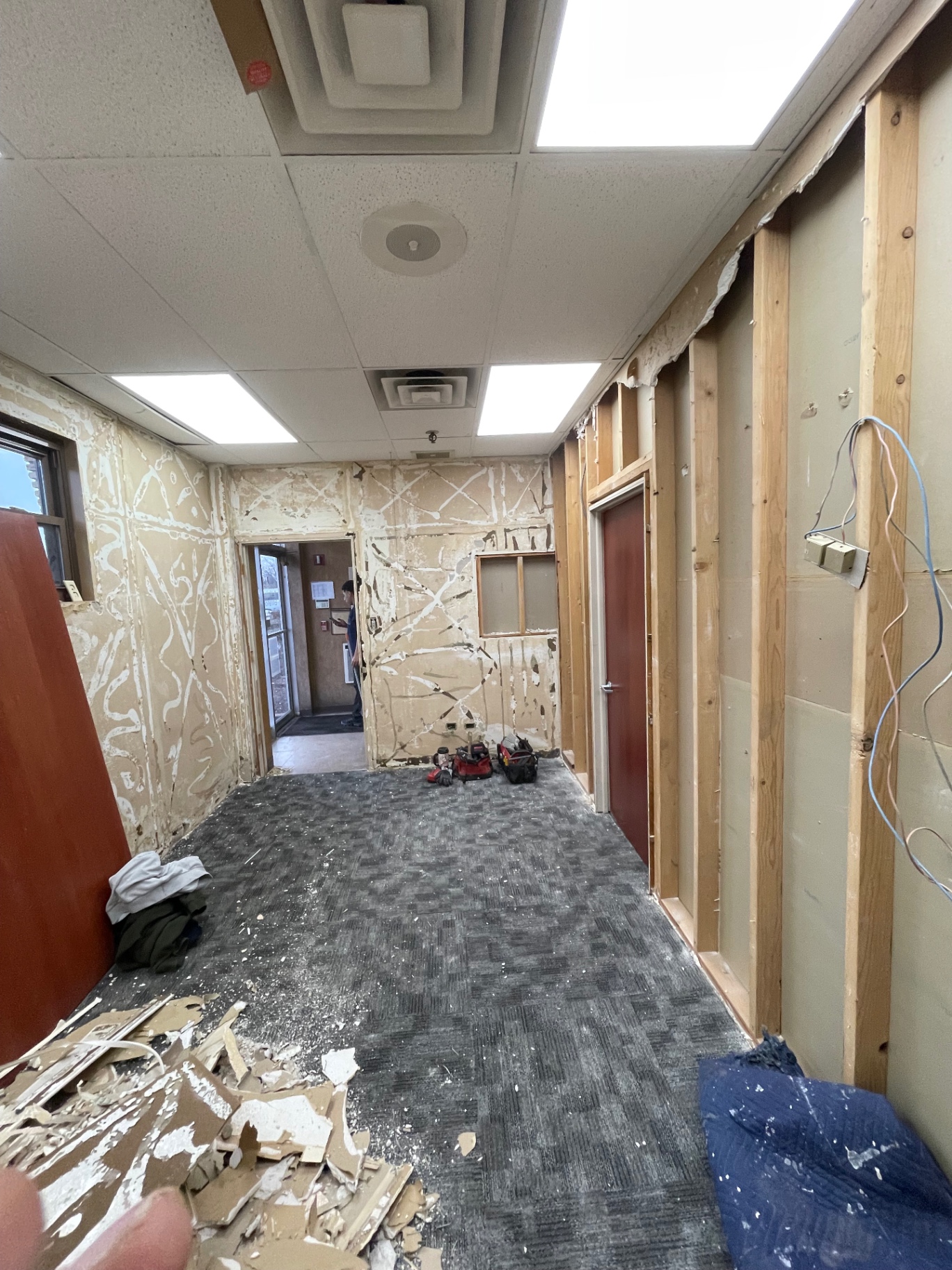 Office hallway with exposed framing and torn-out drywall before installation by R&M Drywall