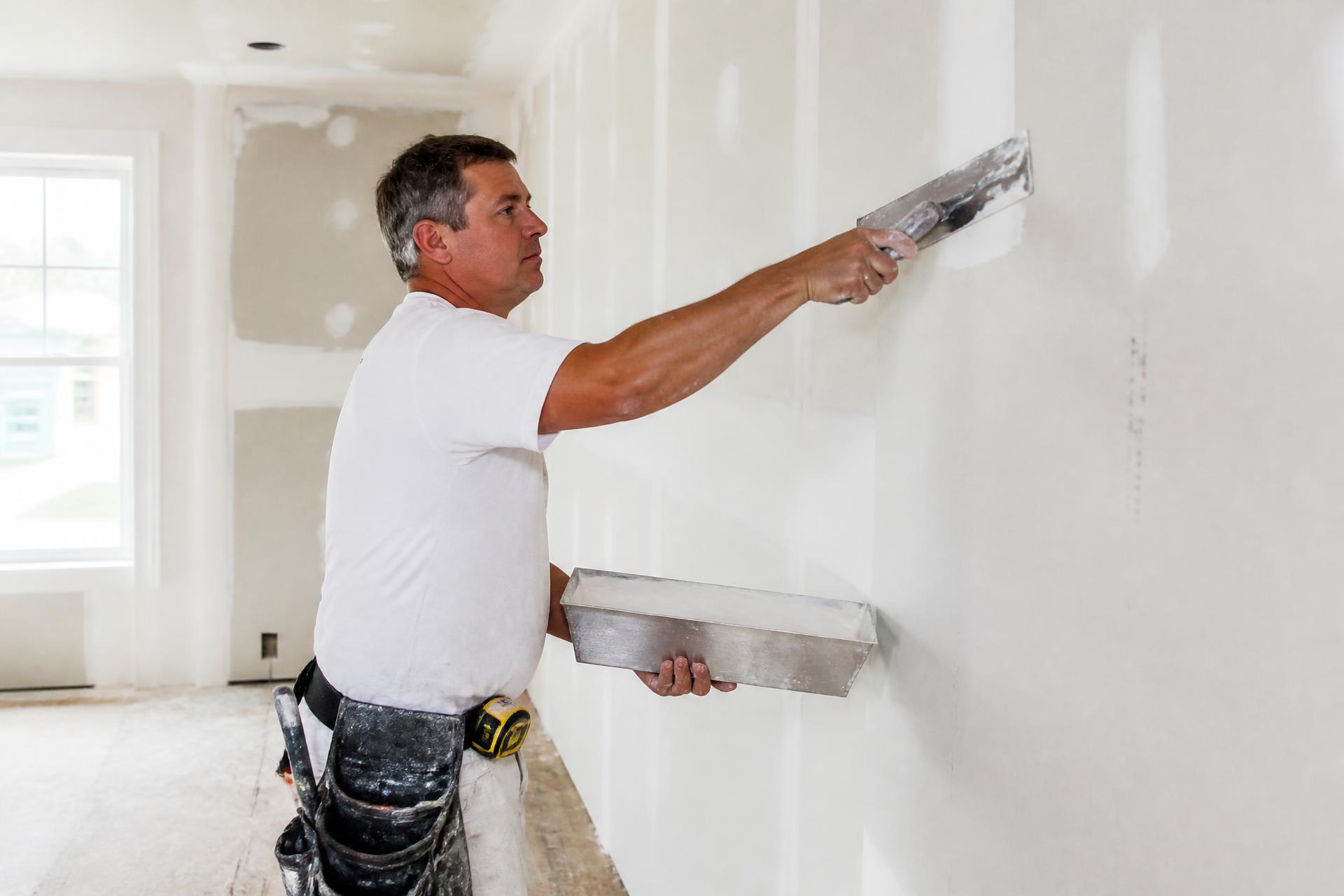 Drywall contractor finishing a drywall seam with a taping knife